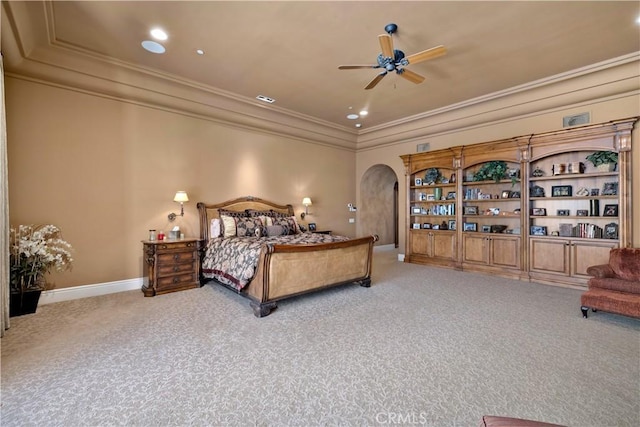 carpeted bedroom featuring a tray ceiling, arched walkways, visible vents, baseboards, and ornamental molding