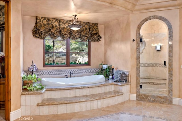 bathroom featuring a bath and a tile shower
