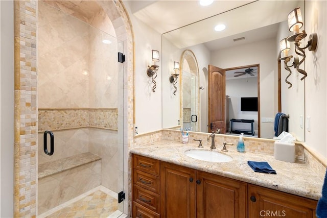 bathroom featuring vanity, ceiling fan, and a shower with shower door