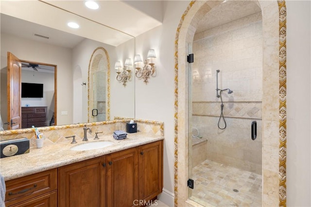 bathroom with vanity, ceiling fan, and walk in shower