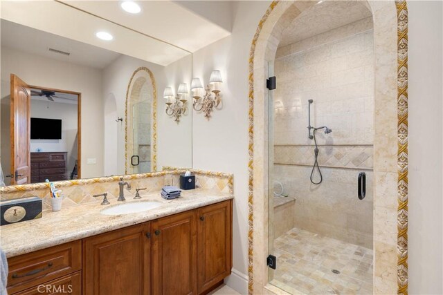bathroom with visible vents, recessed lighting, a ceiling fan, a shower stall, and vanity