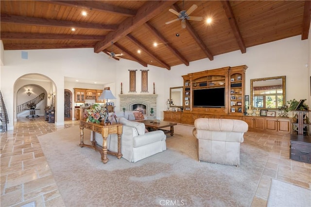 living room with beamed ceiling, ceiling fan, wooden ceiling, and high vaulted ceiling