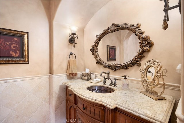 bathroom with vanity and tile walls