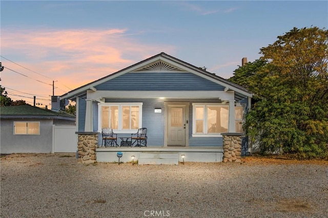 back house at dusk with covered porch