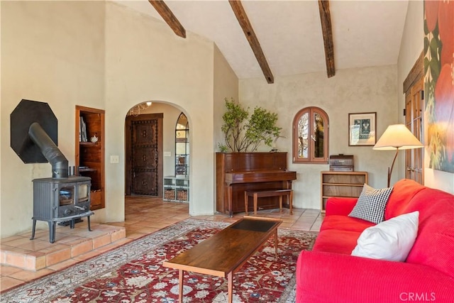 tiled living room with beamed ceiling, high vaulted ceiling, and a wood stove