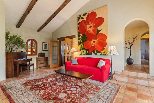 tiled living room with beam ceiling, french doors, and high vaulted ceiling