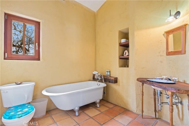 bathroom featuring a tub to relax in, tile patterned flooring, and toilet