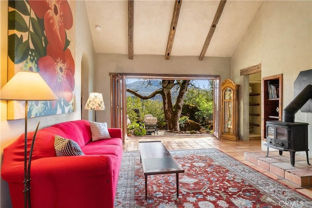 living room with beam ceiling, a wood stove, and high vaulted ceiling