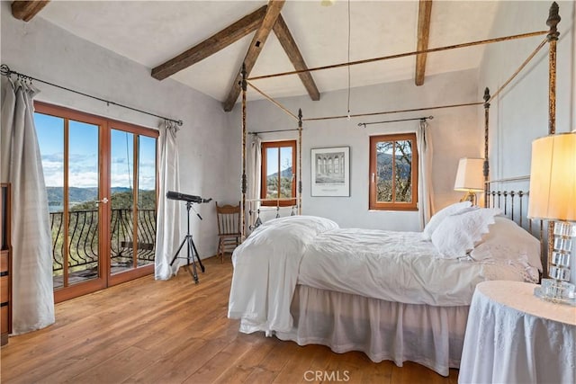 bedroom featuring access to exterior, a mountain view, hardwood / wood-style floors, and beamed ceiling