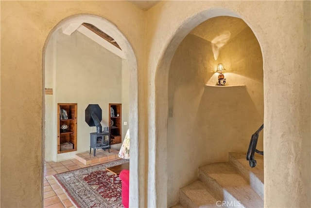 interior space with tile patterned floors and a wood stove