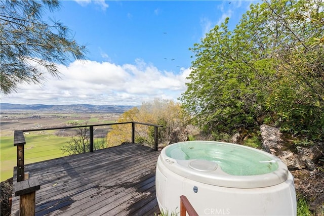 deck with a mountain view and a hot tub