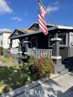 view of front of property with covered porch and a front lawn