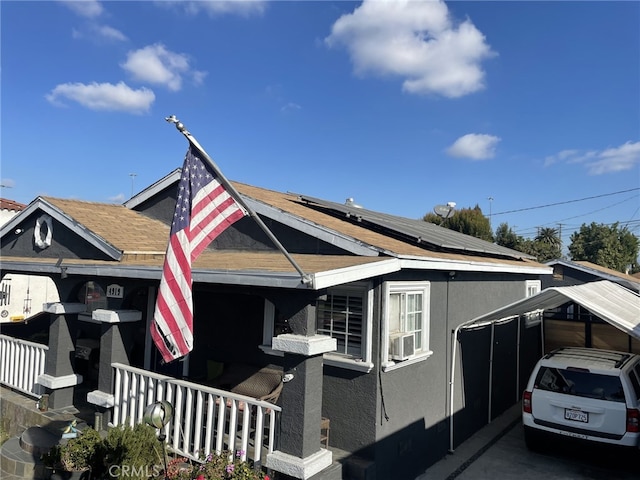 view of side of property featuring covered porch and solar panels