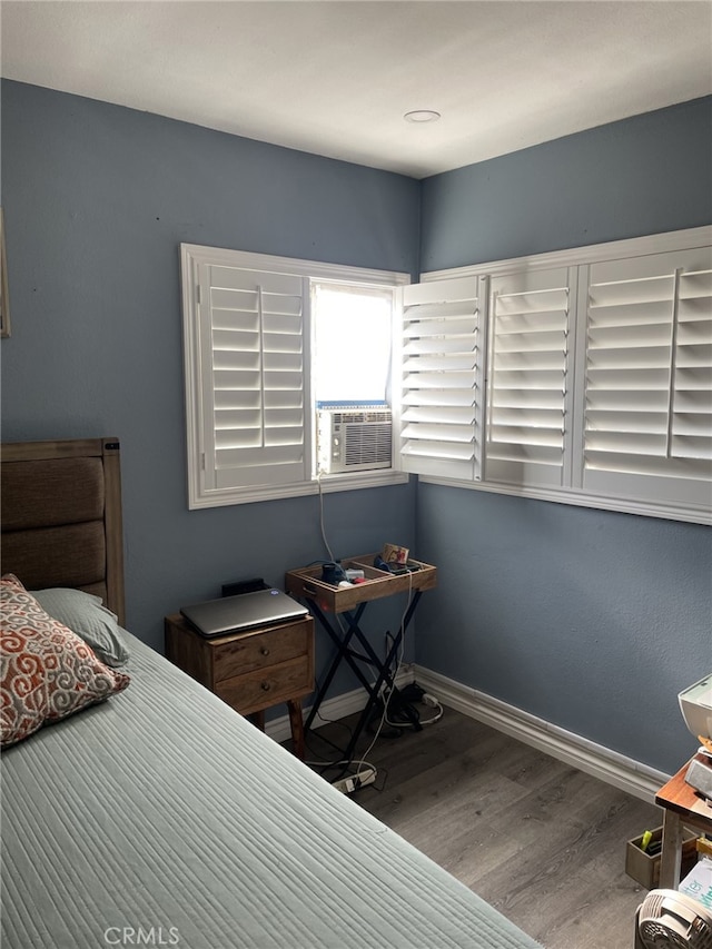 bedroom with wood-type flooring and cooling unit