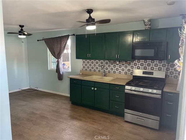 kitchen featuring hardwood / wood-style floors, backsplash, stainless steel stove, and sink