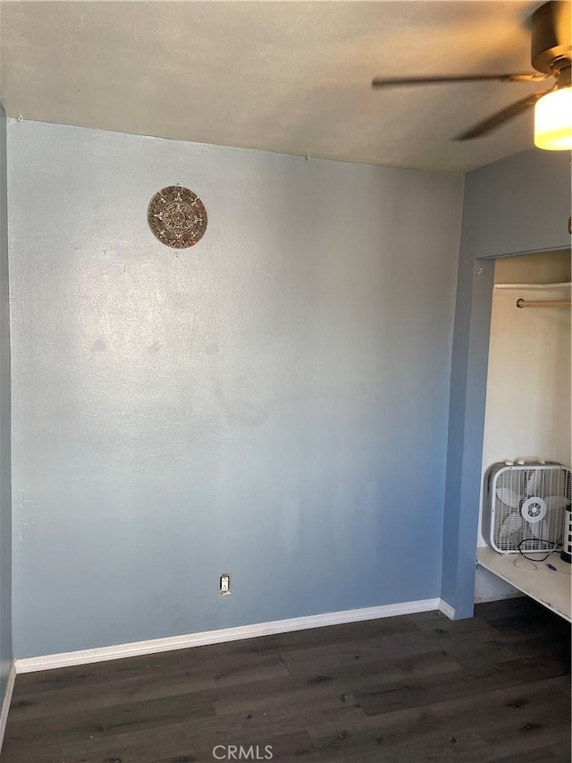 empty room with ceiling fan and dark wood-type flooring