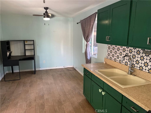 kitchen with ceiling fan, sink, green cabinets, light hardwood / wood-style floors, and decorative backsplash