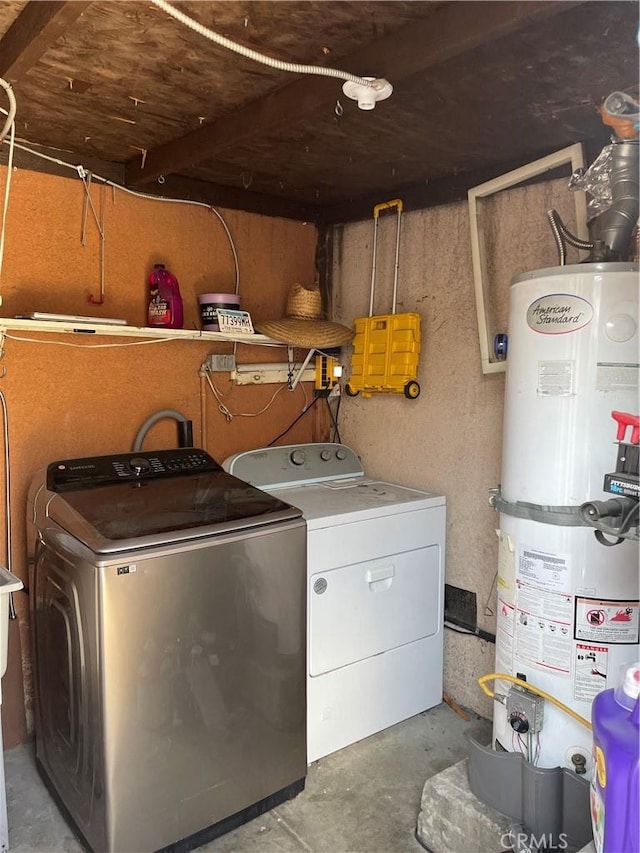 clothes washing area featuring washer and clothes dryer and water heater