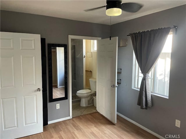 unfurnished bedroom featuring ensuite bathroom, light hardwood / wood-style flooring, and ceiling fan