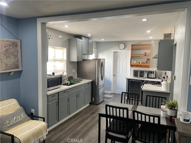 kitchen featuring dark hardwood / wood-style floors, gray cabinets, stainless steel appliances, and sink