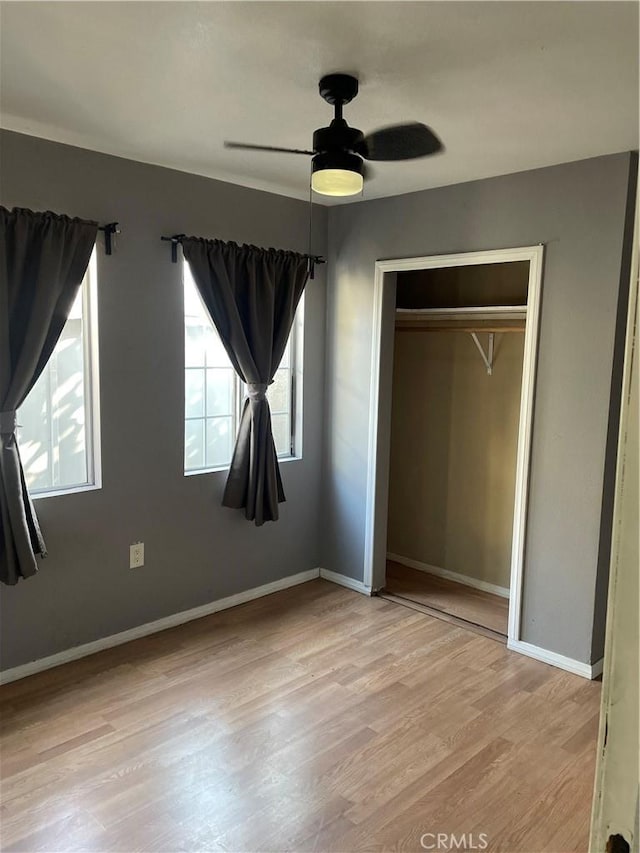 unfurnished bedroom with light wood-type flooring, a closet, and ceiling fan