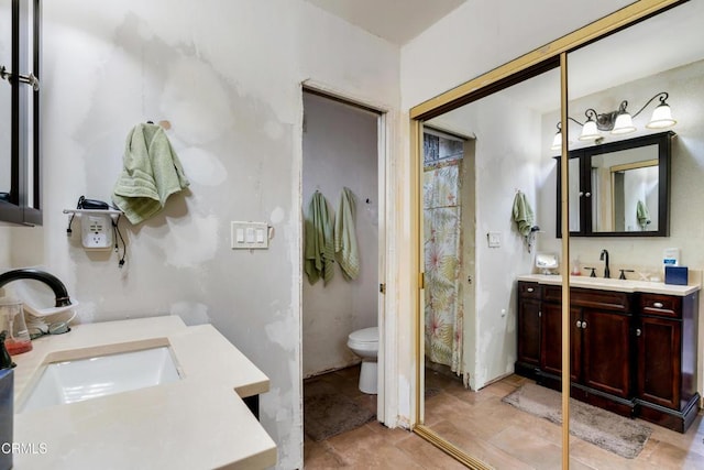 bathroom with tile patterned flooring, vanity, and toilet