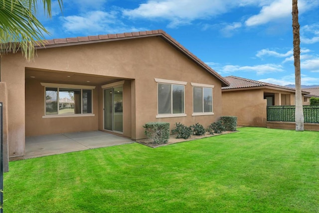 rear view of house featuring a lawn and a patio area