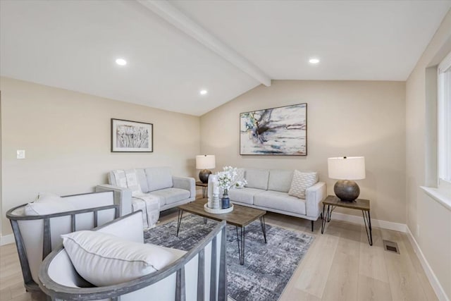 living room featuring vaulted ceiling with beams and light wood-type flooring