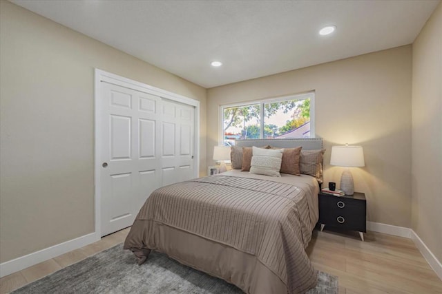 bedroom with light hardwood / wood-style floors and a closet