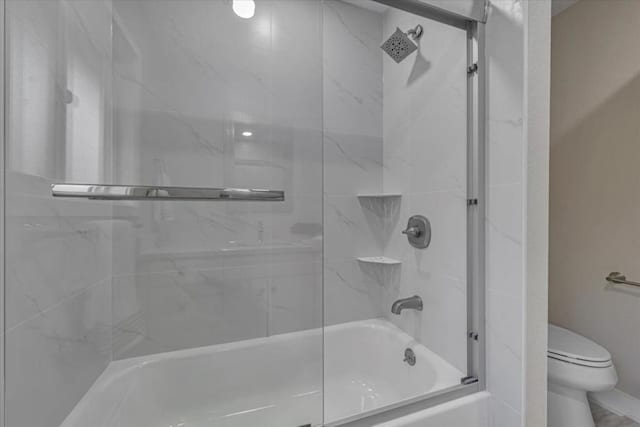 bathroom with shower / bath combination with glass door and toilet