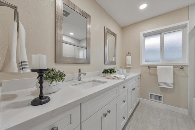 bathroom with vanity and a shower