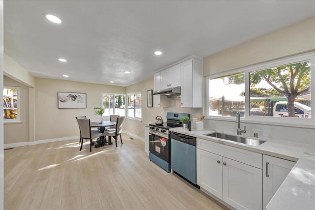 kitchen featuring sink, stainless steel appliances, light stone countertops, light hardwood / wood-style floors, and white cabinets