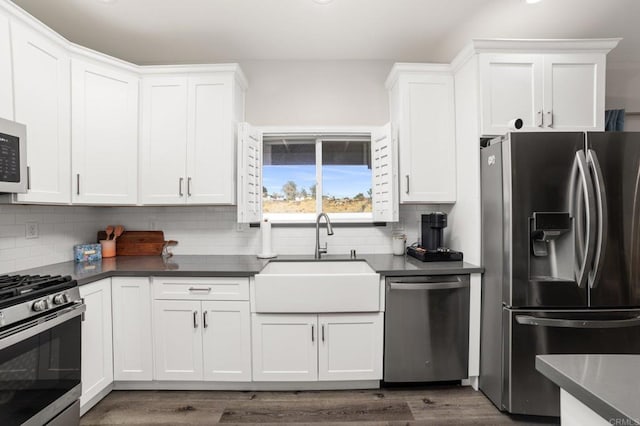 kitchen featuring dark hardwood / wood-style flooring, sink, white cabinets, and appliances with stainless steel finishes