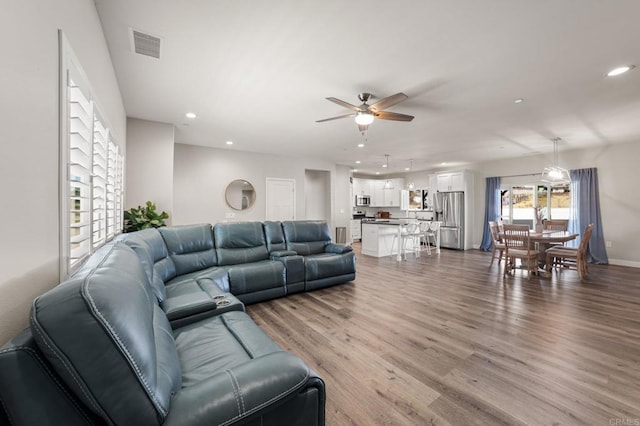 living room featuring wood-type flooring and ceiling fan