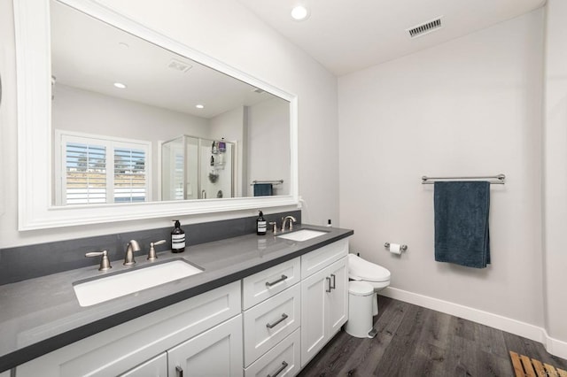 bathroom with toilet, an enclosed shower, wood-type flooring, and vanity