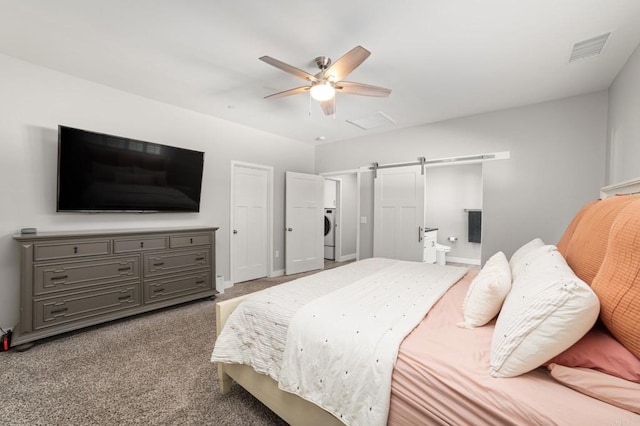 bedroom featuring a barn door, light colored carpet, washer / clothes dryer, and ceiling fan