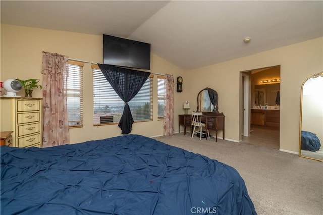 bedroom with multiple windows, ensuite bath, carpet floors, and vaulted ceiling