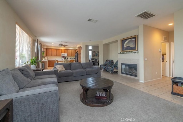 living room with ceiling fan, a fireplace, and light tile patterned flooring