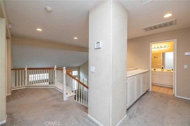 hall with light colored carpet