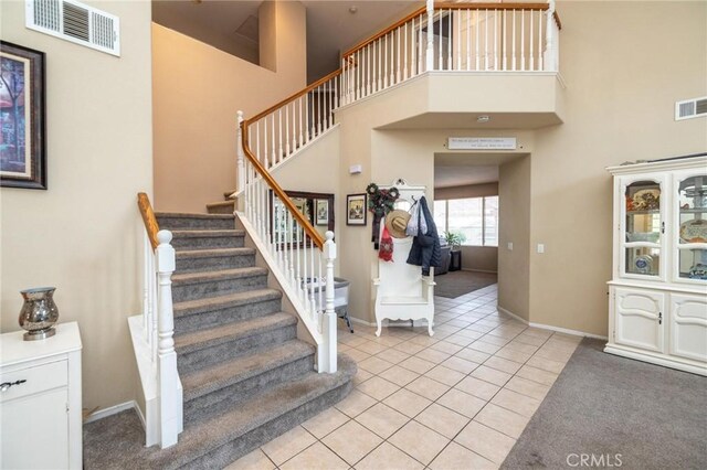 entryway featuring a towering ceiling and light tile patterned flooring