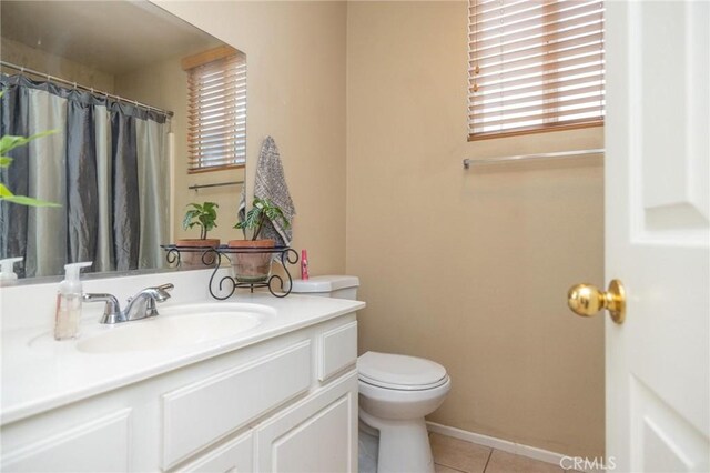 bathroom featuring toilet, vanity, and tile patterned flooring