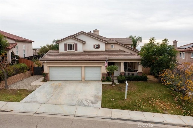 traditional-style house featuring a tile roof, covered porch, fence, driveway, and a front lawn