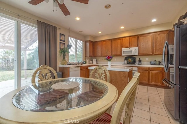 kitchen with ceiling fan, light tile patterned floors, white appliances, and a center island