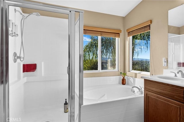 bathroom with plenty of natural light, vanity, separate shower and tub, and vaulted ceiling