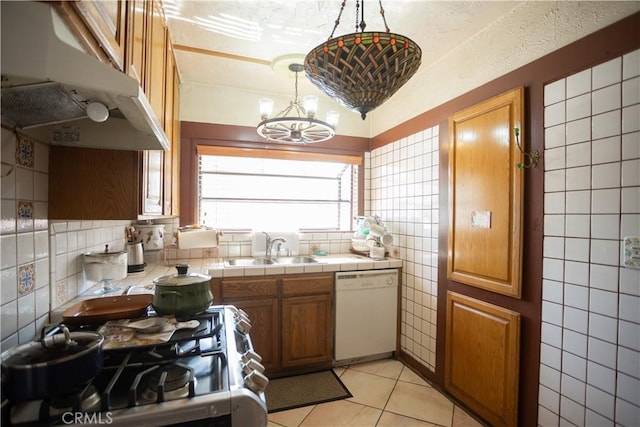 kitchen featuring dishwasher, hanging light fixtures, stainless steel range oven, tile countertops, and light tile patterned floors