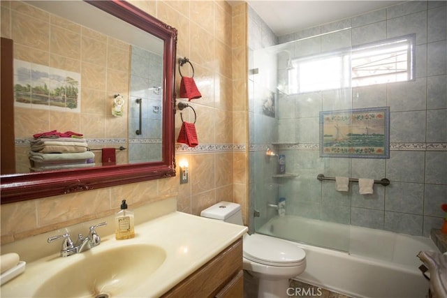 full bathroom with bath / shower combo with glass door, toilet, decorative backsplash, vanity, and tile walls