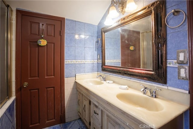 bathroom with tile patterned flooring, vanity, tile walls, and a shower with shower door