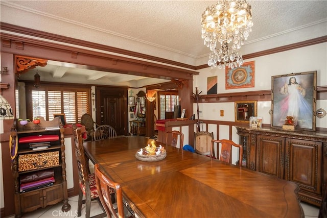 tiled dining room featuring crown molding, a chandelier, and a textured ceiling