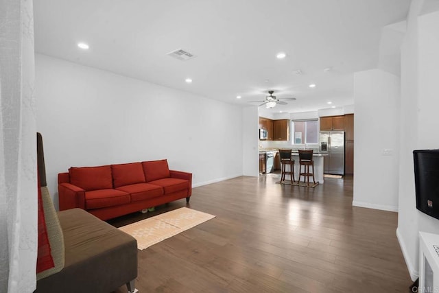 living room with ceiling fan and dark wood-type flooring