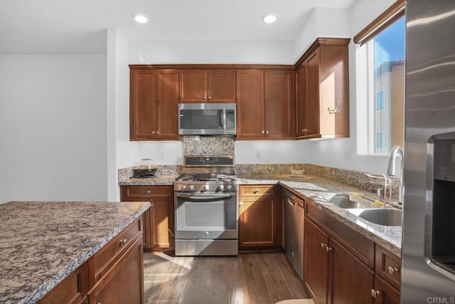 kitchen featuring light stone countertops, stainless steel appliances, dark hardwood / wood-style floors, and sink